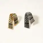 Etiquettes d'oreilles artisanales palestiniennes en métal doré et argenté, motifs traditionnels hexagonaux et géométriques, accessoires de mode uniques inspirés de la culture palestinienne.