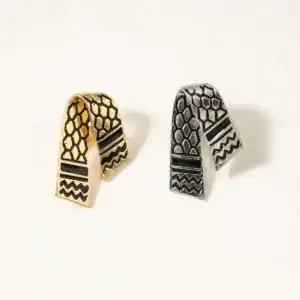 Etiquettes d'oreilles artisanales palestiniennes en métal doré et argenté, motifs traditionnels hexagonaux et géométriques, accessoires de mode uniques inspirés de la culture palestinienne.