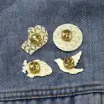 Boutons de chemise en or avec motif géométrique et feuilles en relief, parfaits pour accessoires de mode élégants et sophistiqués.